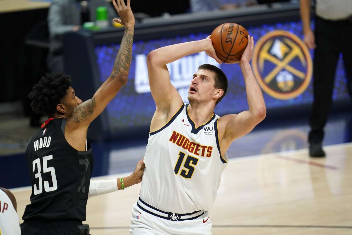 Denver Nuggets center Nikola Jokic, right, shoots over Houston Rockets forward Christian Wood in the first half of an NBA basketball game Monday, Dec. 28, 2020, in Denver. (AP Photo/David Zalubowski)