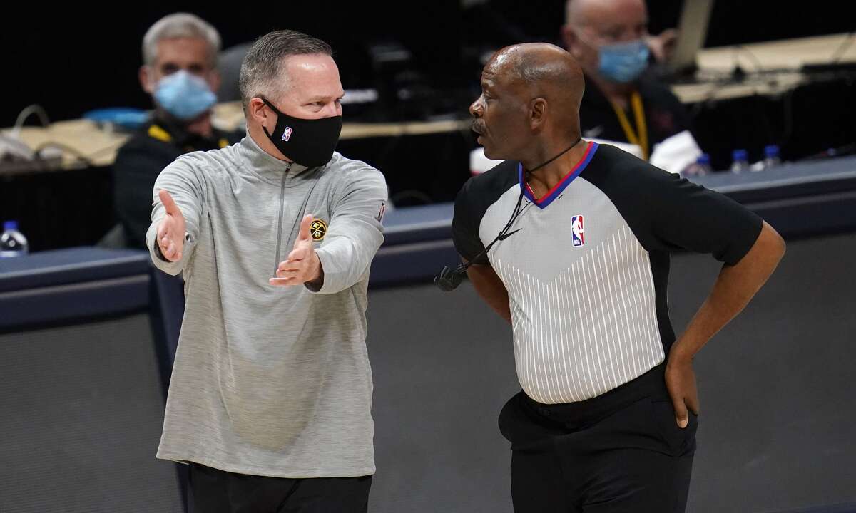 Denver Nuggets coach Michael Malone, left, argues a call with referee Derek Richardson during the first half of the team's NBA basketball game against the Houston Rockets on Monday, Dec. 28, 2020, in Denver. (AP Photo/David Zalubowski)