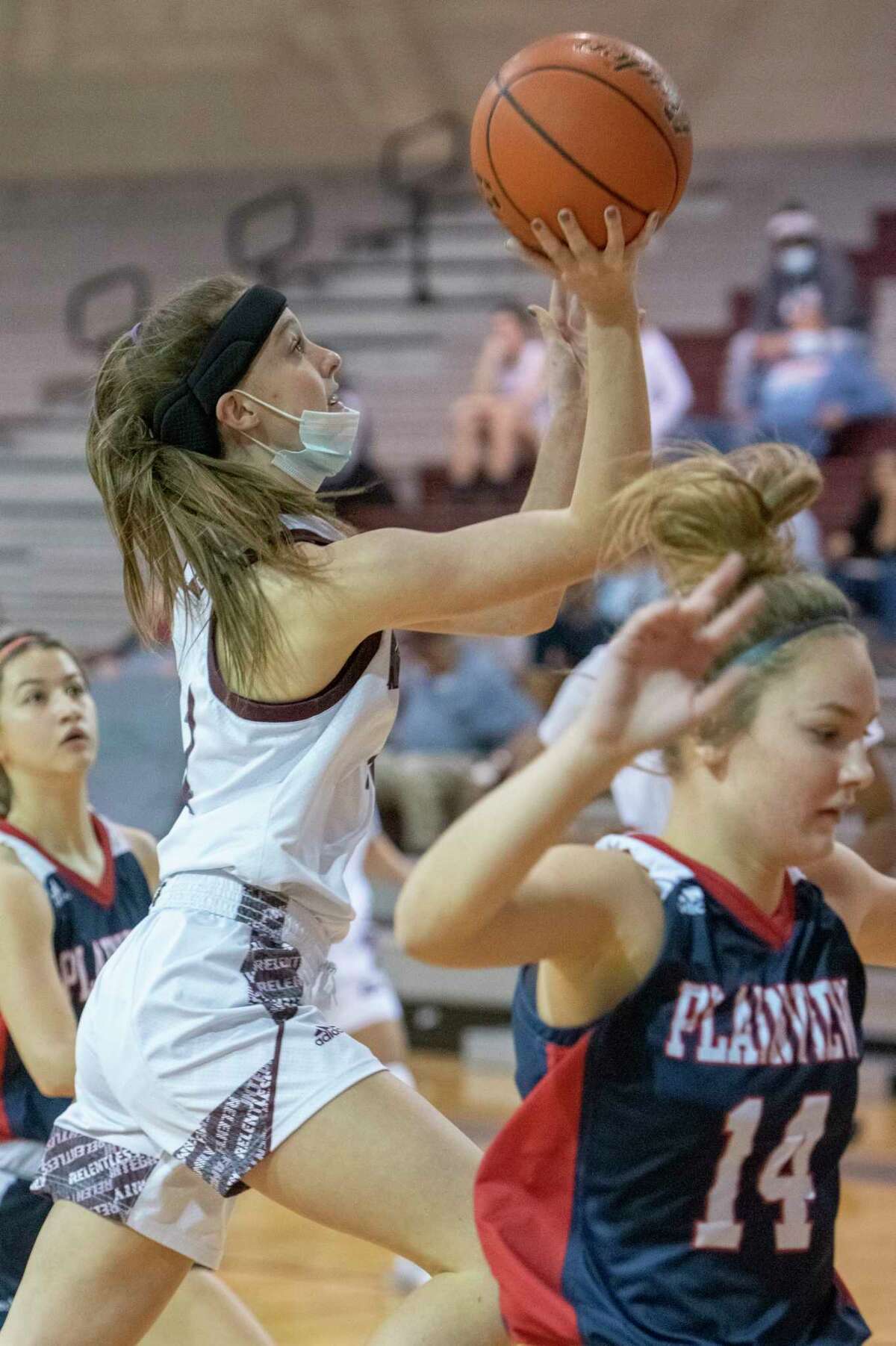 Lee High's Maggie Erdwurm drives to the basket as Plainview's Katy Long runs past 12/29/2020 at the Lee High gym. Tim Fischer/Reporter-Telegram