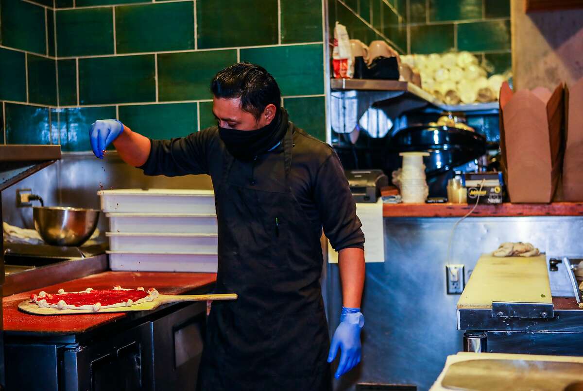 Sous chef Gabriel Diaz builds a pizza at Gather Kitchen, Bar and Market in Berkeley. The pandemic is the first time Gather has done takeout, and its dropped the menu prices and focused on comfort foods like pizza to be more accessible.