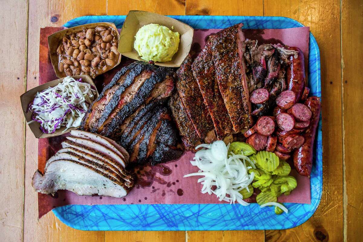 This 2017 file photo shows pinto beans, potato salad, pork ribs, pulled pork, sausage, pickles, onions, brisket, turkey and cole slaw from Franklin Barbecue in Austin, Texas.