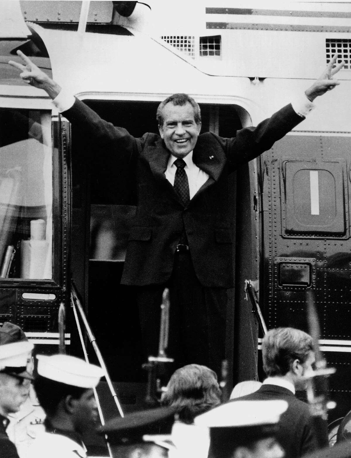 Richard Nixon says goodbye with a victorious salute to his staff members outside the White House as he boards a helicopter after resigning the presidency on Aug. 9, 1974.