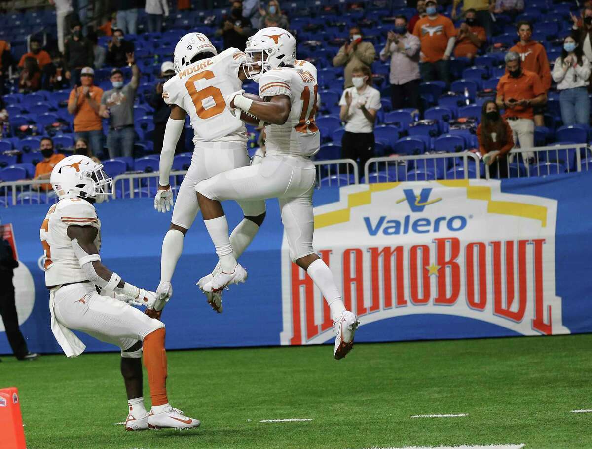 Texas receiver Kelvontay Dixon (16) celebrates his touchdown with teammate Joshua Moore (06) against Colorado in the fourth quarter during the 2020 Valero Alamo Bowl at the Alamodome on Tuesday, Dec. 29, 2020.