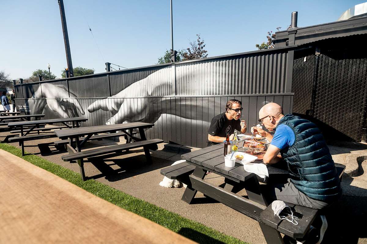 Dennis Pilarinos (left) and Mike Dauber eat at Horn Barbecue in Oakland in October 2020.