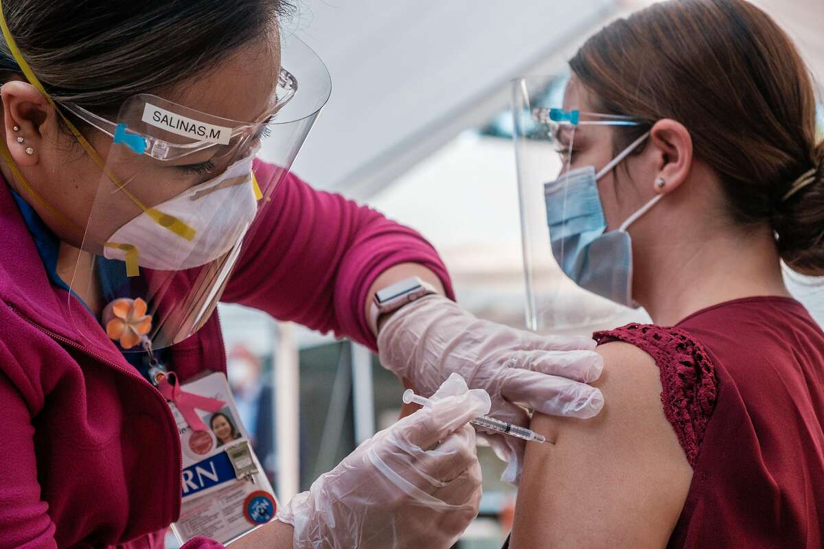 Teri Grados, a registered nurse at the San Francisco Campus for Jewish Living receives the Coronavirus vaccine in San Francisco on Monday, December 21, 2020. Jewish Living, one of San Francisco's largest skilled nursing facilities, started to vaccinate workers.
