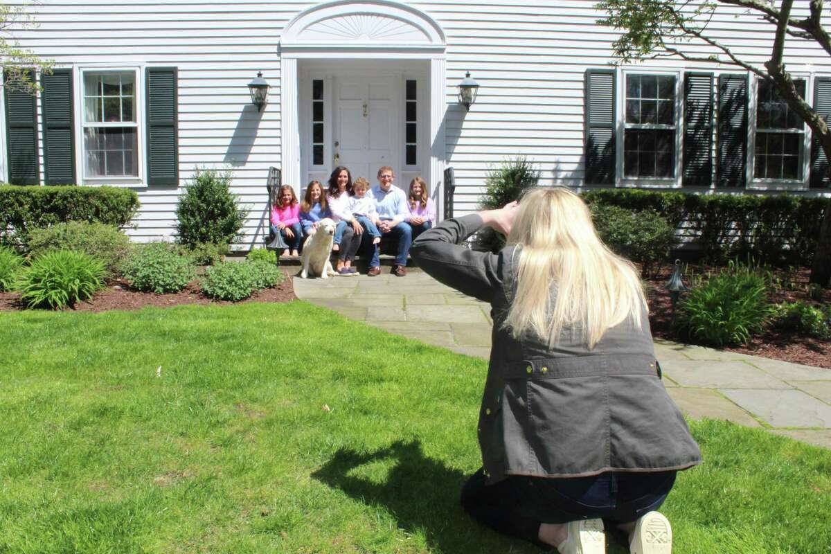 Meghan Murphy Gould photographs the Schlafman family as part of the Front Steps Project in New Canaan Saturday, April 25. Joining Andrea Chalon, Andrea Ceraso, Christina Saburro and Meghan Murphy Gould of New Canaan are Andrew Stanbrick and Christine Brennan of West Hartford, Katherine Calderwood and Mary Wade of Darien, Ashley Rutledge of Berlin, Cindy Ringer of Madison, Danielle Coleman of Old Greenwich, Leslie Massaro of Windsor, Rob Faber of Suffield, Ryan Finnegan of Putnam and Xenia Gross of Wilton. “It was a pretty huge undertaking,” said Cara Soulia of Needham, founder of the Front Steps Project. “There were hundreds of photographers from all over the world who participated. We chose a couple hundred of the book. There was a limit on pages.” The book comes in at 240 pages. Proceeds are going to the United Way, Soulia said. “It wasn’t an exact science,” Soulia said. “We never published a book before. We did the best we could.”
