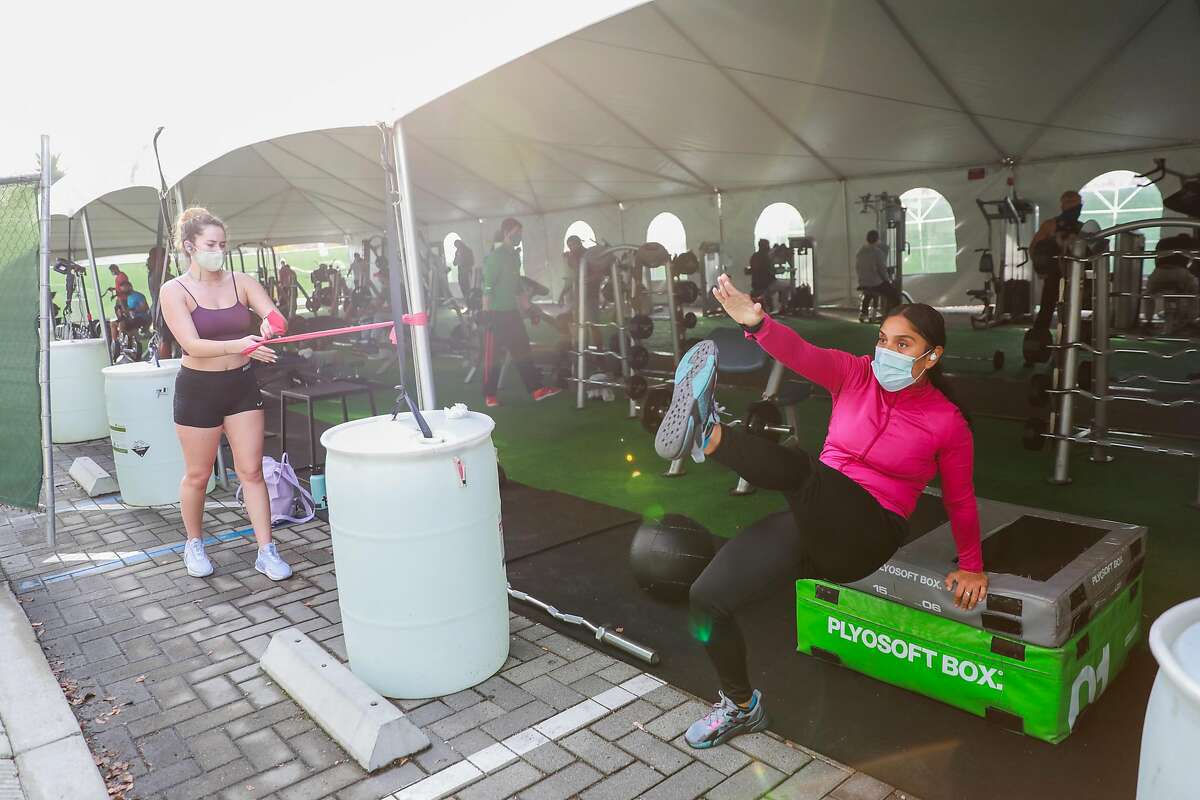 (L-r) Jenny Toohey and Kat Velasquez exercise in the outdoor tent at 24 Hour Fitness in Walnut Creek, California on Wednesday, Dec. 16, 2020.