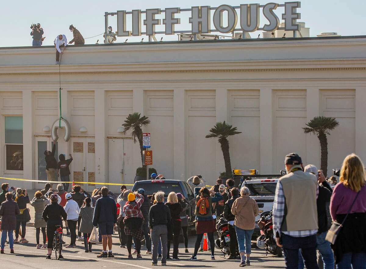 A crowd of nostalgic longtime customers and onlookers gathered to watch the sign for the Cliff House, a trademarked name, taken down.