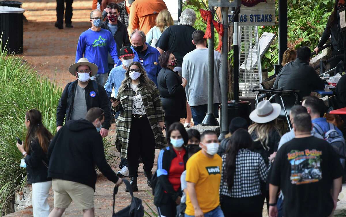 People crowd along the River Walk Tuesday prior to the Alamo Bowl. Visitors are asked to wear their masks as part of COVID-19 protection protocols.