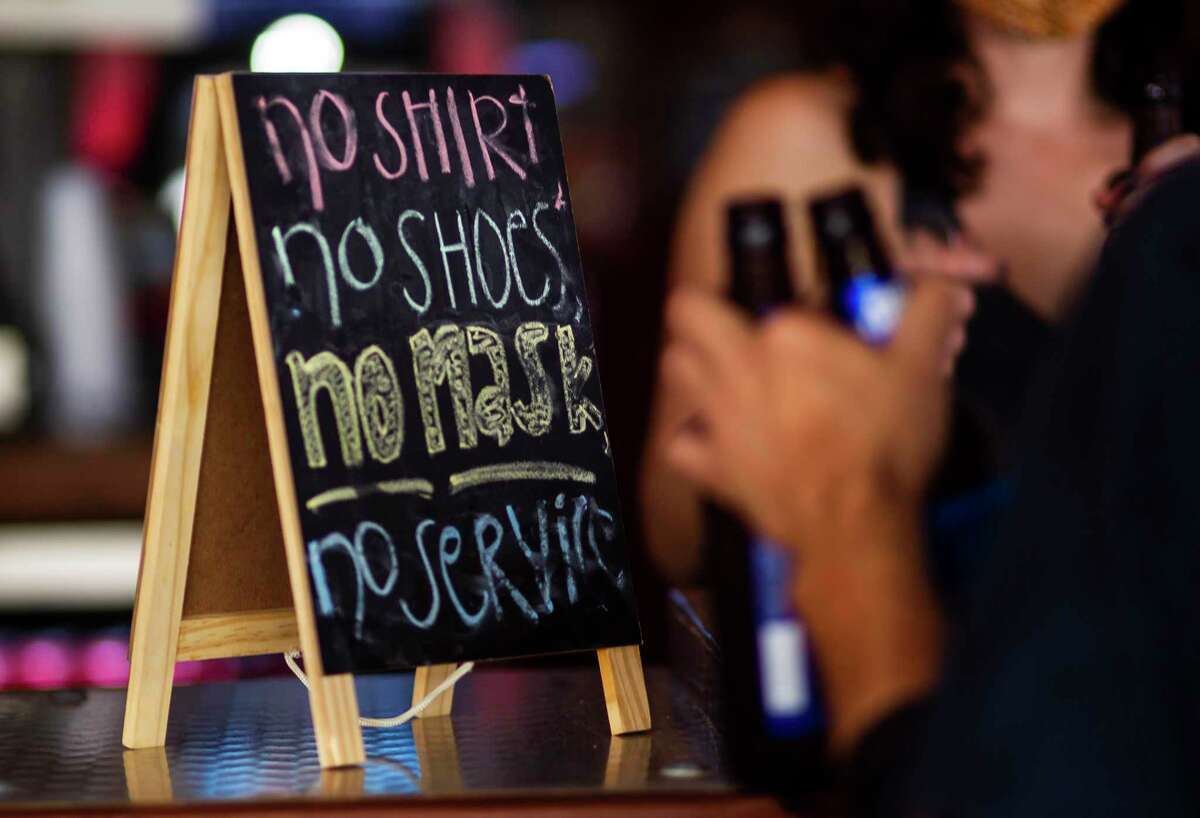 A sign on the bar at the West Alabama Ice House reminds patrons that they need a mask to be served, Saturday, Oct. 3, 2020, in Houston.