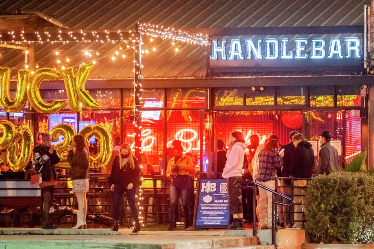 People wait to enter Handlebar on Washington Avenue to celebrate New Year’s Eve on Thursday, Dec. 31, 2020, in Houston.
