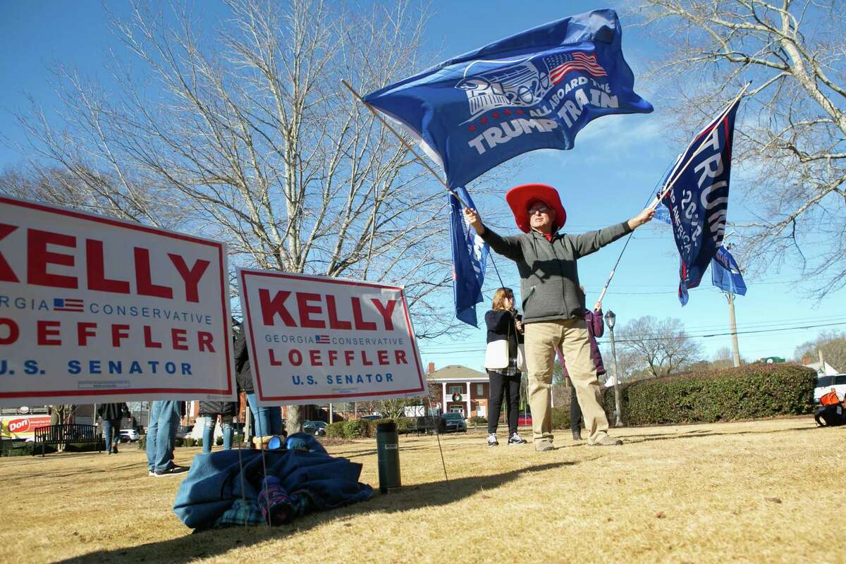 WOODSTOCK, GA - DECEMBER 29: Gary White waves Trump flags during a Senate Firewall campaign rally for Sen. Kelly Loeffler (R-GA) at The Park at City Center on December 29, 2020 in Woodstock, Georgia. Loeffler faces Democratic Senate candidate Raphael Warnock in the runoff election that will determine control of the U.S. Senate. With a week until the January 5th runoff election, candidates continue to campaign throughout Georgia. (Photo by Jessica McGowan/Getty Images)