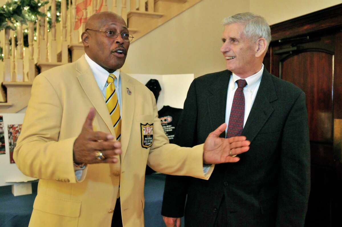 SPORTS-HAMDEN-Pro football hall of famer, Floyd Little (L) talks about the difference that Robert Schreck's (R) encouragement, made in his life. The two men are attending the Gridiron Club Halll of Fame Awards Dinner. Melanie Stengel/Register 12/09/10