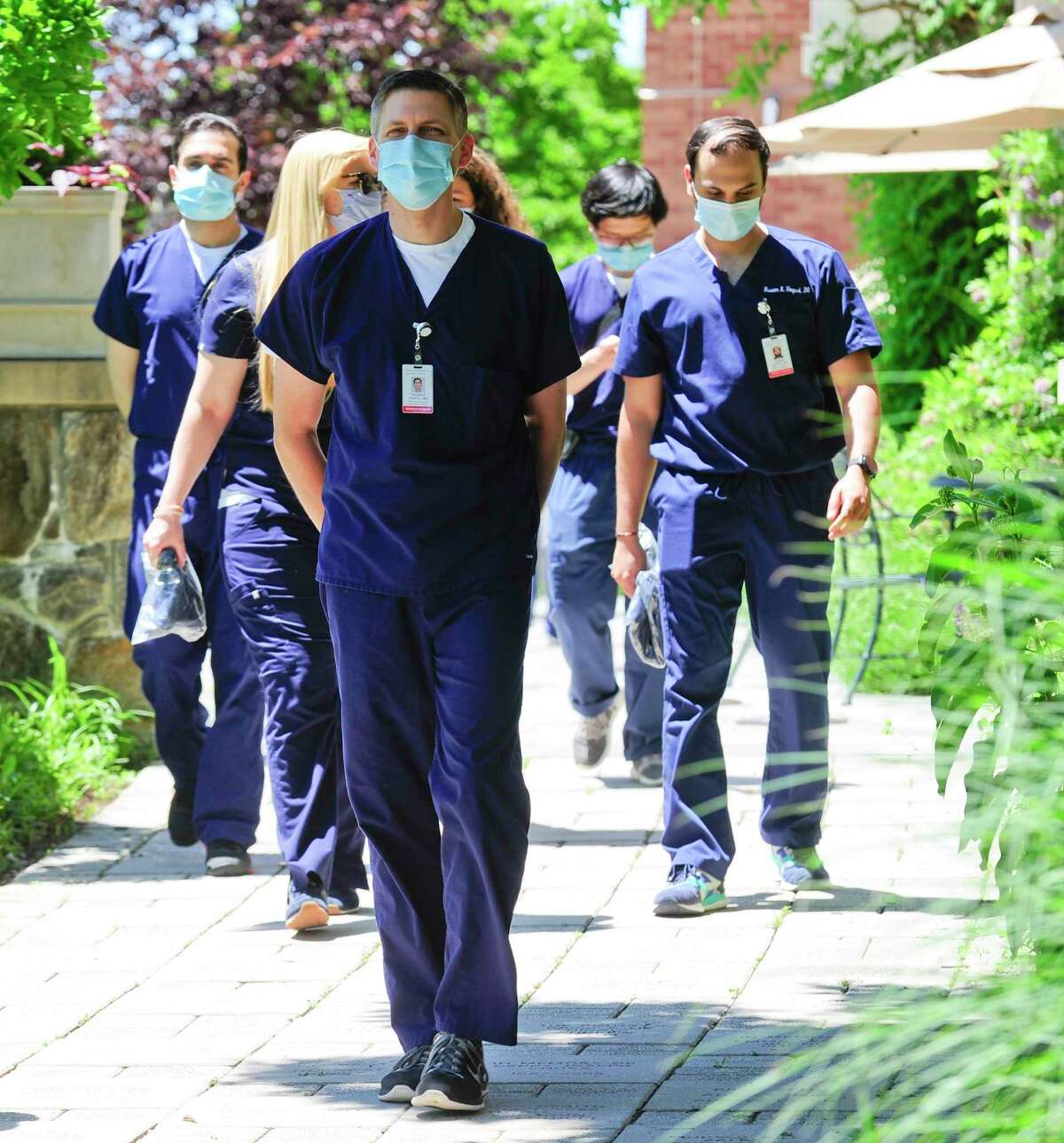 Doctors of Greenwich Hospital Internal Medicine Residency Program walk to the gardens for a post graduation photo on June 12, 2020 in Greenwich, Connecticut. This is a group of doctors were pressed into service as rookies to help treat COVID patients in the ICU and for bedside care.
