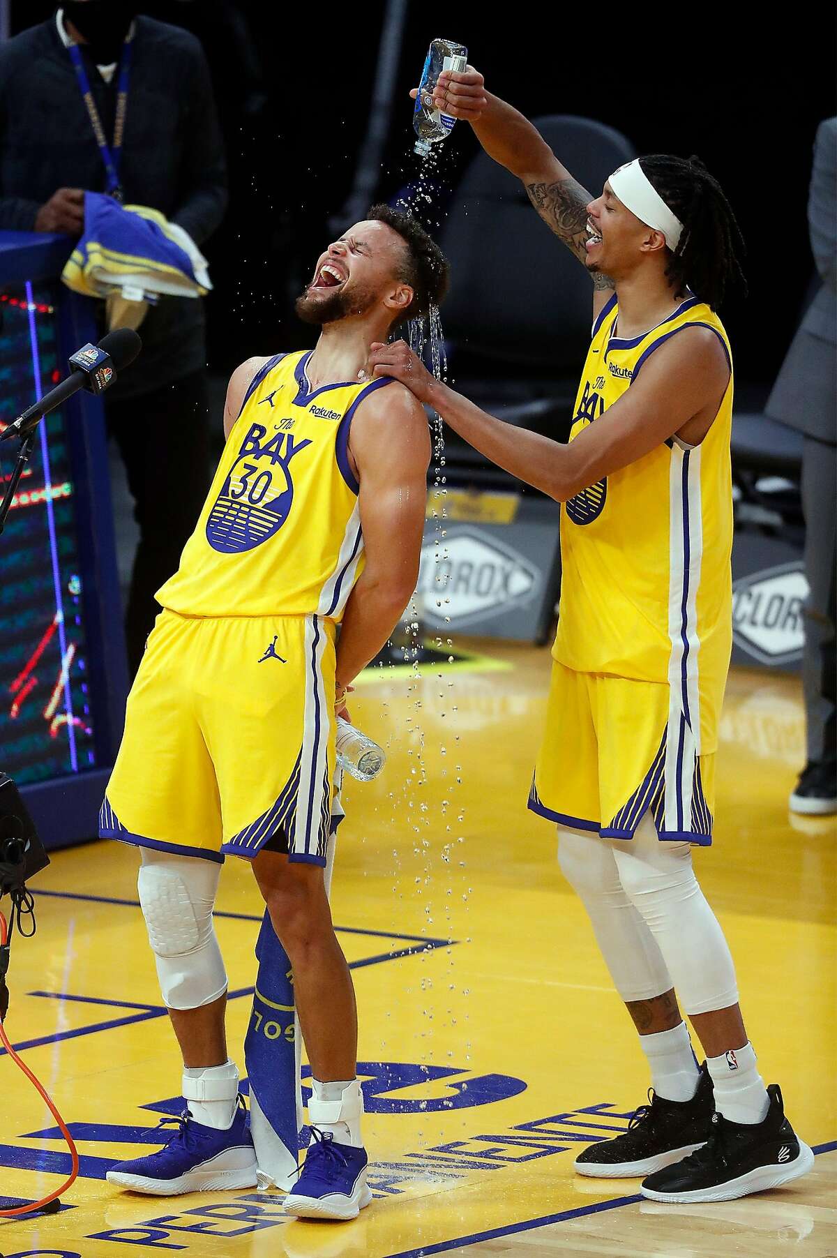 After scoring a career high 62 points, Golden State Warriors' Stephen Curry gets a bottle of water poured on him by Damion Lee after Warriors' 137-122 win over Portland Trail Blazers in NBA game at Chase Center in San Francisco, Calif., on Sunday, January 3, 2021.