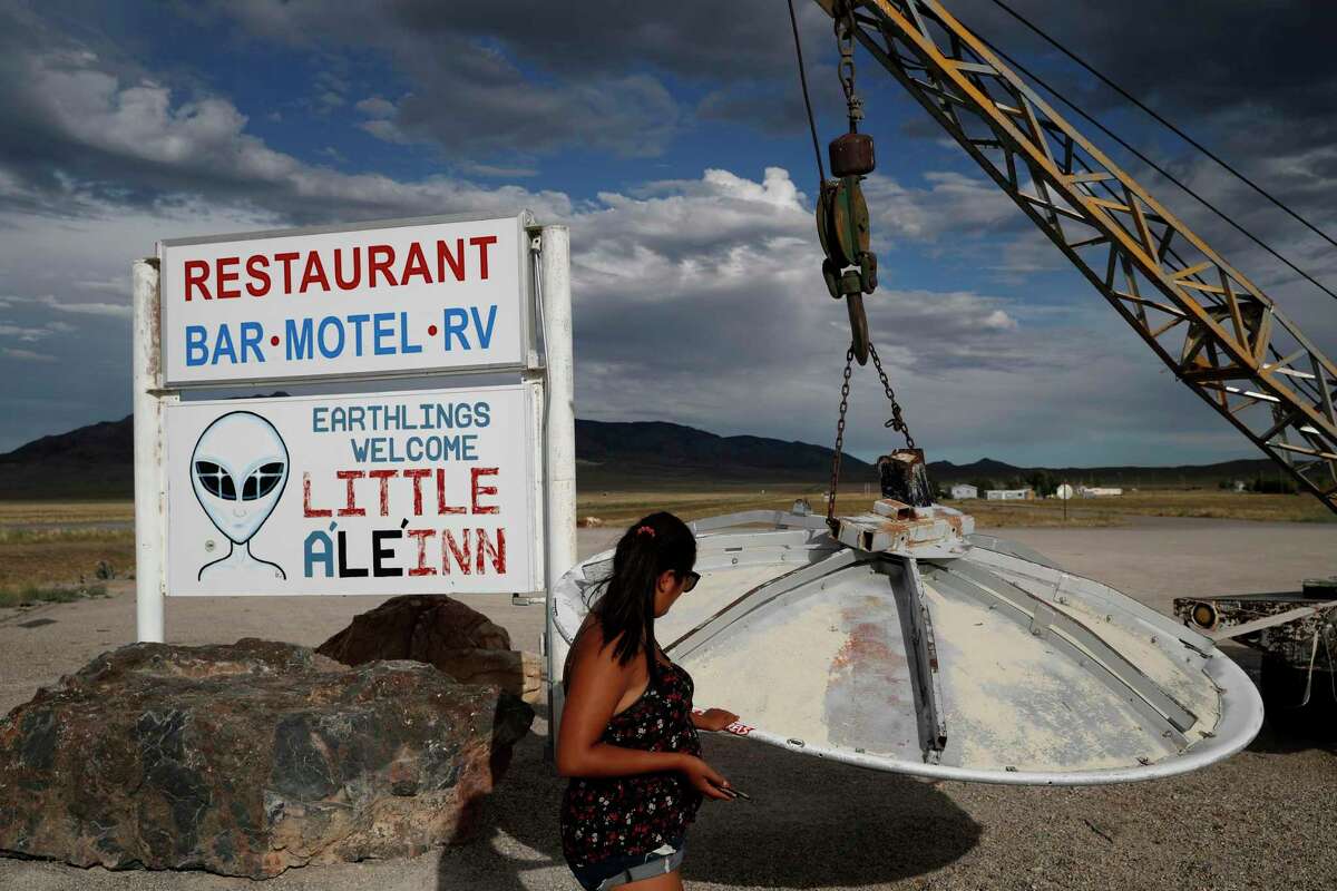 In this July 22, 2019 photo, Grace Capati looks at a UFO display outside of the Little A'Le'Inn, in Rachel, Nev., the closest town to Area 51. The U.S. Air Force has warned people against participating in an internet joke suggesting a large crowd of people "storm Area 51," the top-secret Cold War test site in the Nevada desert. There were about 600 reported sightings in the United States in February, which is only slightly higher than than the monthly average. Since 2017, there has been an average of 454 reported UFO sightings. There were 816 reports in March, and 1,040 in April.