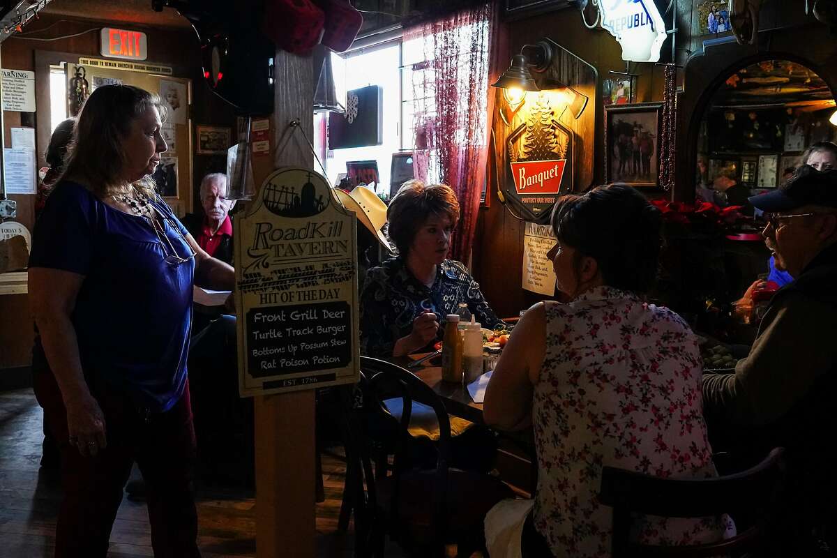 Robbie Nelson talks with customers inside her Airport Bar & Grill in Mariposa, Calif. Many local residents arrived for lunch and drinks in support of Nelson’s defiance of COVID-19 regulations. Very few wore masks.