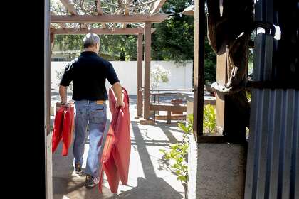 Fume Bistro owner Terry Letson carries cushions for outdoor seating at his restaurant in Napa last May.