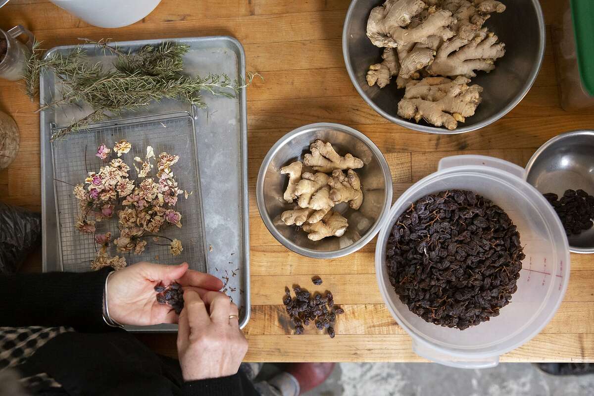 June Taylor painstakingly de-stems raisins she's been dehydrating for Christmas cakes at her kitchen in Berkeley, Calif. on Monday, January 4, 2021. After 17 years in her current space and over 30 years of preserving, June Taylor is going to be closing down her business and kitchen.