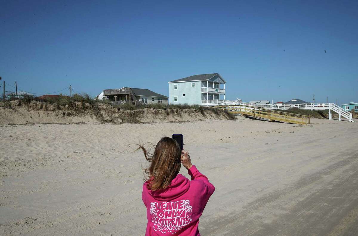 Toni Capretta, president of Save Our Beach Association, takes photos of storm-damaged dunes to send to the GLO on Tuesday, Jan. 5, 2021, in Surfside Beach.