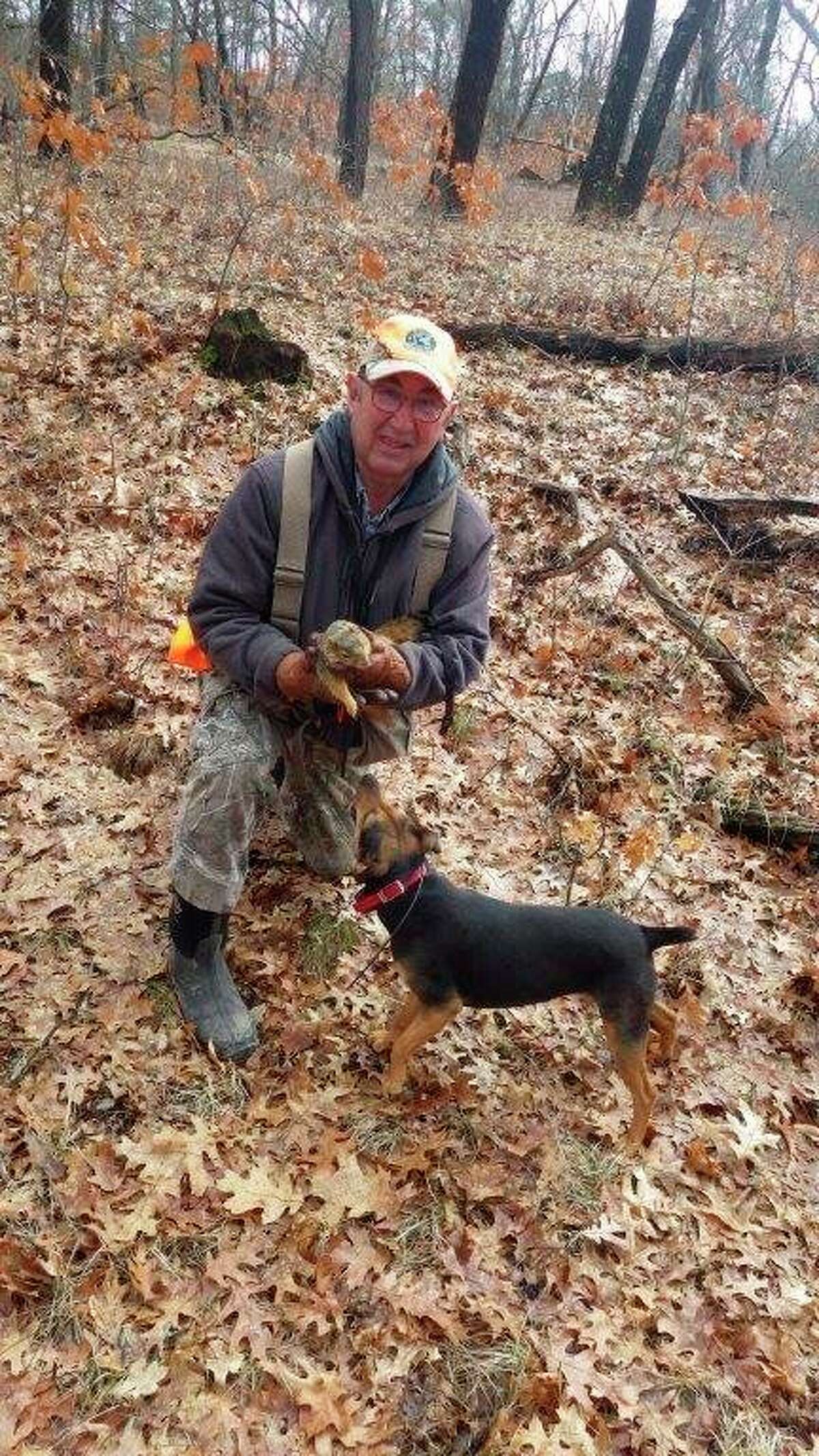 Bill Blohm of Akron and his Barger Stock Feist, Pepper, are pictured with a fox squirrel that Pepper had treed. Michigan's squirrel season runs to the end of March, and using squirrel dogs is a great winter pastime which can offer plenty of action. (Tom Lounsbury/Hearst Michigan)