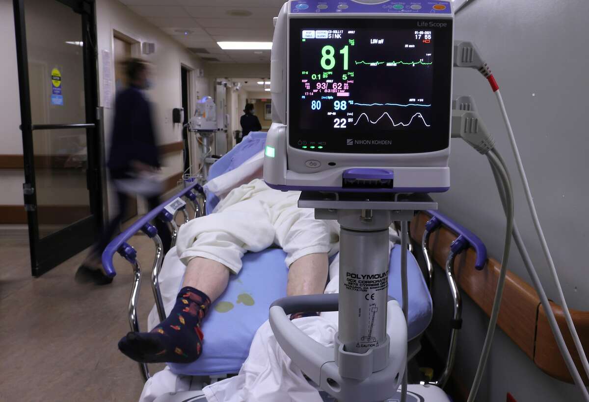 APPLE VALLEY, CALIFORNIA - JANUARY 05: A patient lies on a stretcher in a hallway in the overloaded Emergency Room at Providence St. Mary Medical Center amid a surge in COVID-19 patients in Southern California on January 5, 2021 in Apple Valley, California. California has issued a new directive ordering hospitals with space to accept patients from other hospitals which have run out of ICU beds due to the coronavirus pandemic. The order could result in patients being shipped from Southern California to Northern California as Southern California continues to have zero percent of its remaining ICU (Intensive Care Unit) bed capacity. (Photo by Mario Tama/Getty Images)