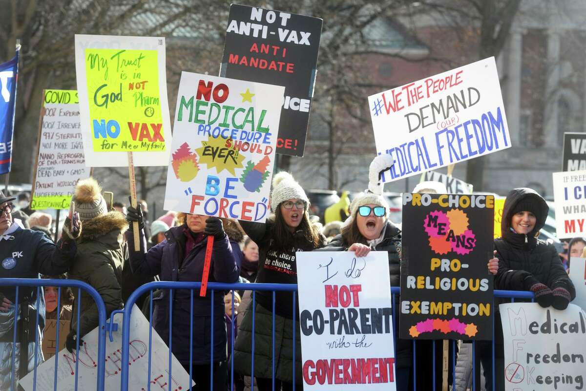 Hundreds of people lined up behind barricades to protest during the of the start the legislative session held outside at the State Capitol, in Hartford, Conn. Jan. 6, 2021.