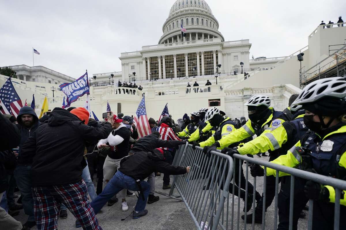 Trump supporters try to break through a police barrier, Wednesday, Jan. 6, 2021, at the Capitol in Washington. As Congress prepared to affirm President-elect Joe Biden's victory, thousands of people gathered to show their support for President Donald Trump and his claims of election fraud. (AP Photo/Julio Cortez)