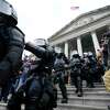 Police in riot gear walk out of the Capitol, Wednesday, Jan. 6, 2021, in Washington. As Congress prepares to affirm President-elect Joe Biden's victory, thousands of people have gathered to show their support for President Donald Trump and his claims of election fraud. (AP Photo/Manuel Balce Ceneta)