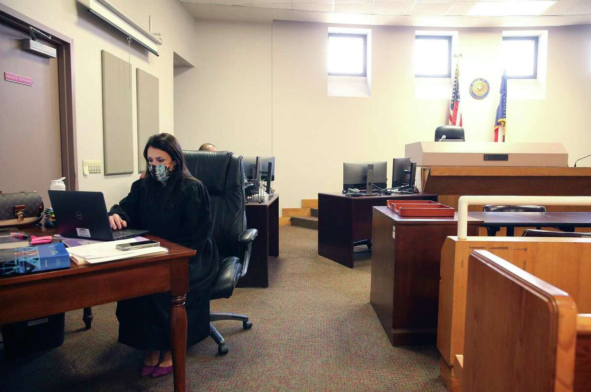 Judge Jackie Valdés works on her laptop inside the courtroom while renovations are made on her future office.