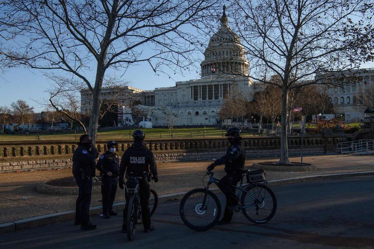 Members of the Capitol police and the Secret Service chat in front of the US Capitol in Washington, DC, on January 7, 2021, one day after supporters of outgoing President Donald Trump stormed the building. (Photo by NICHOLAS KAMM/AFP via Getty Images)