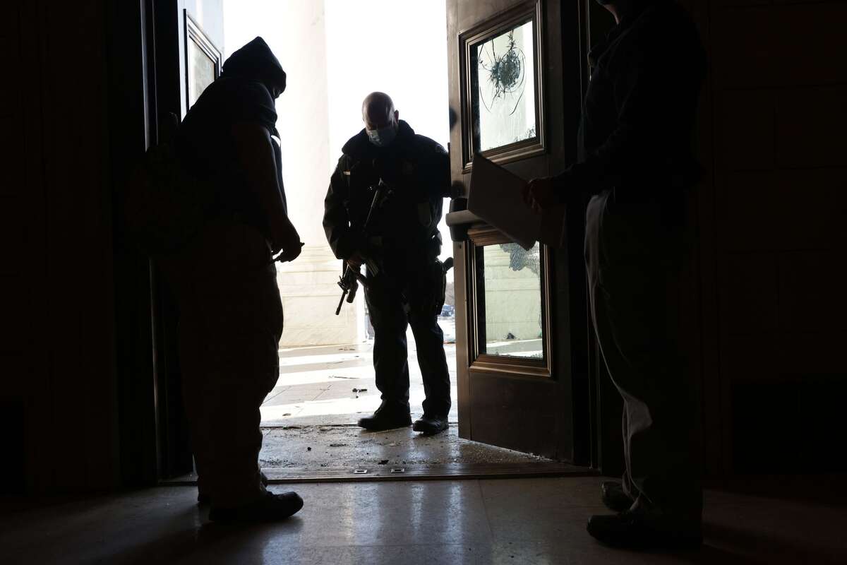 Members of the U.S. Capitol Police test open a damaged entrance of the U.S. Capitol January 7, 2021 in Washington, DC. The U.S. Congress has finished the certification for President-elect Joe Biden and Vice President-elect Kamala Harrisâ electoral college win after pro-Trump mobs stormed the Capitol and temporarily stopped the process. (Photo by Alex Wong/Getty Images)