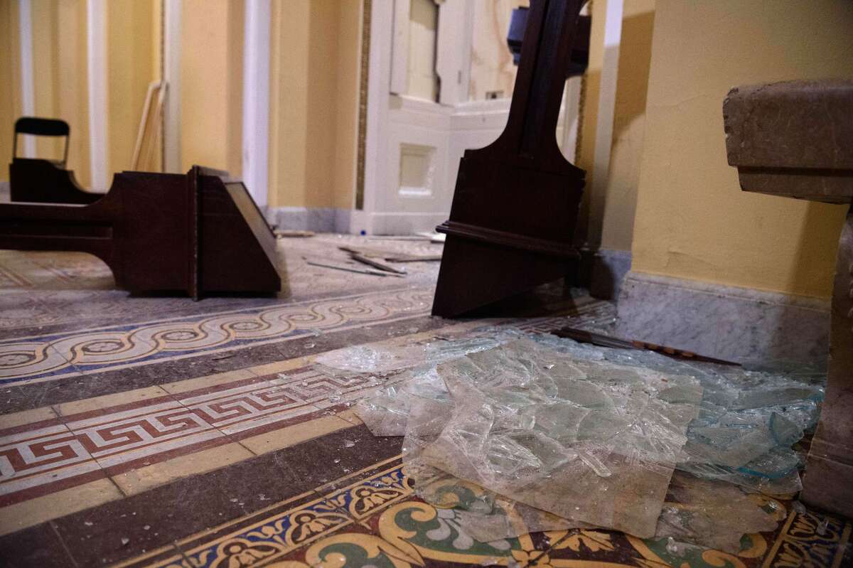 Overturned furniture and broken glass litter a hallway of the US Capitol in Washington, DC, on January 7, 2021, one day after supporters of outgoing President Donald Trump stormed the building. (Photo by NICHOLAS KAMM/AFP via Getty Images)