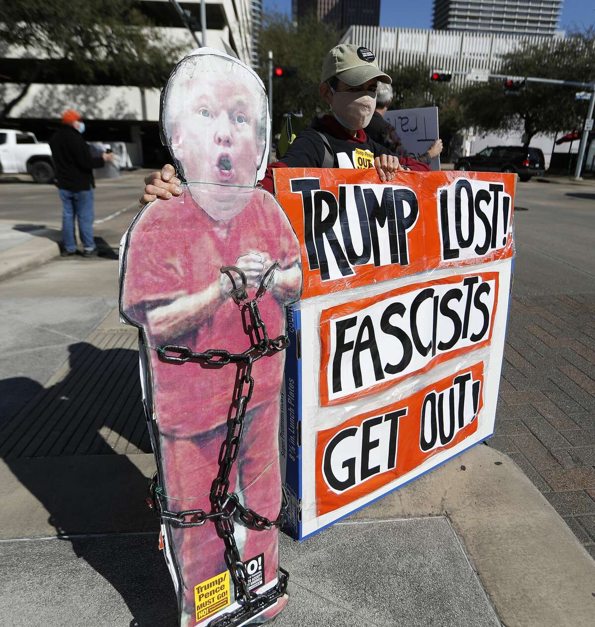 A protester holds a cardboard cutout of Donald Trump in chains as Houston activists call for Senator Ted Cruz to resign at the Leland Federal Building, Thursday, Jan. 7, 2021, in Houston.