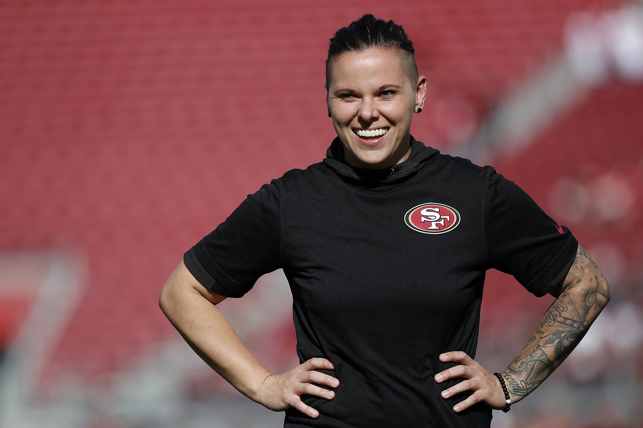 San Francisco 49ers offensive assistant coach Katie Sowers, left, tosses a  ball to players duri …