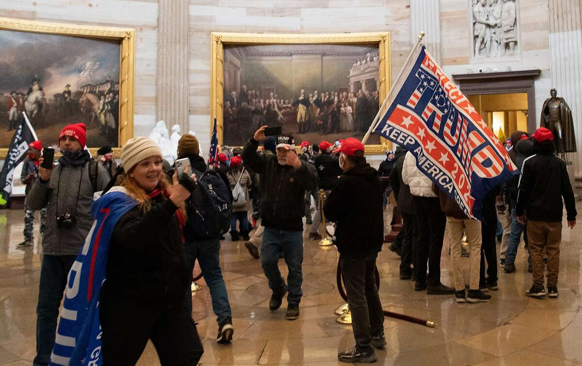Jenny Cudd (bottom left) was among the protesters that made their way into the U.S. Capitol building on Jan. 6, 2021, as some breached the floors of the House and Senate, causing lawmakers to be evacuated. (Photo by SAUL LOEB / AFP) (Photo by SAUL LOEB/AFP via Getty Images)