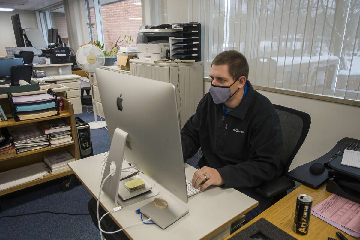 In this file photo, Matt Thomas works in a temporary workspace for MCTV Wednesday, Jan. 6, 2021 inside the Grace A. Dow Memorial Library, which is still undergoing renovations after sustaining severe damage during the mid-Michigan dam failures and flood in May. (Katy Kildee/kkildee@mdn.net)