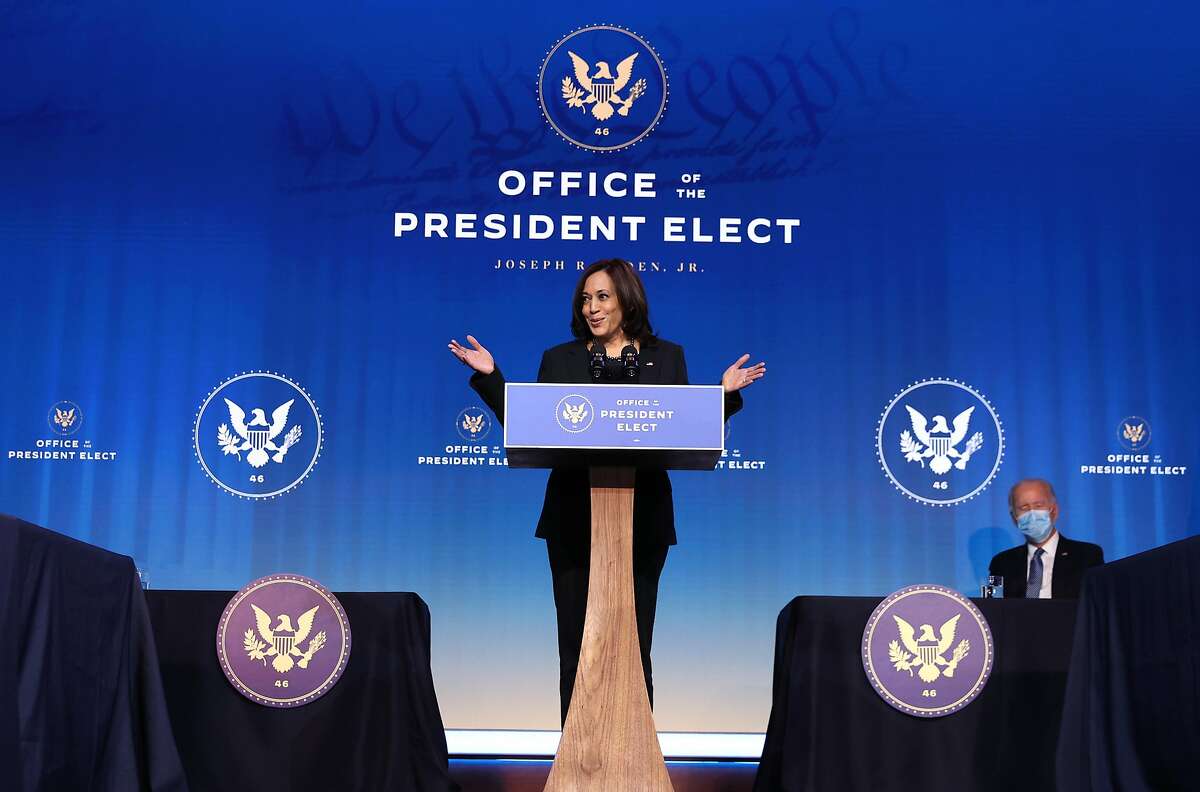 U.S. Vice President-elect Kamala Harris delivers remarks as President-elect Joe Biden looks on at The Queen theater Jan. 7, 2021, in Wilmington, Del.