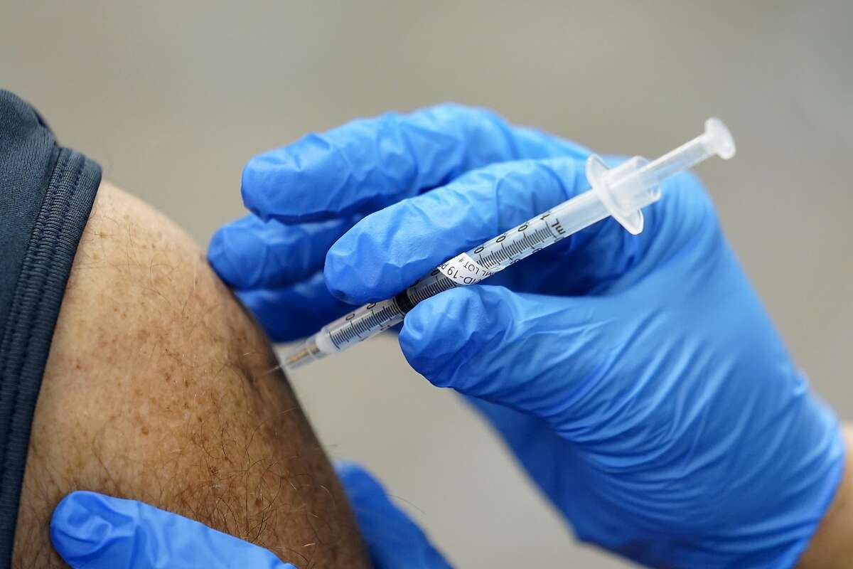 In this Jan. 5, 2021, file photo, a health care worker receives a second Pfizer-BioNTech COVID-19 vaccine shot.