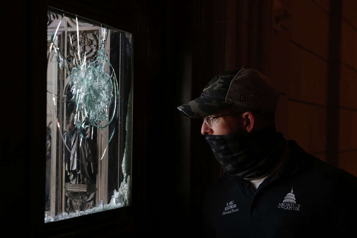 A member of the Architect of the Capitol inspects a damaged entrance of the U.S. Capitol January 7, 2021 in Washington, DC. The U.S. Congress has finished the certification for President-elect Joe Biden and Vice President-elect Kamala Harris' electoral college win after pro-Trump mobs stormed the Capitol and temporarily stopped the process. (Photo by Alex Wong/Getty Images
