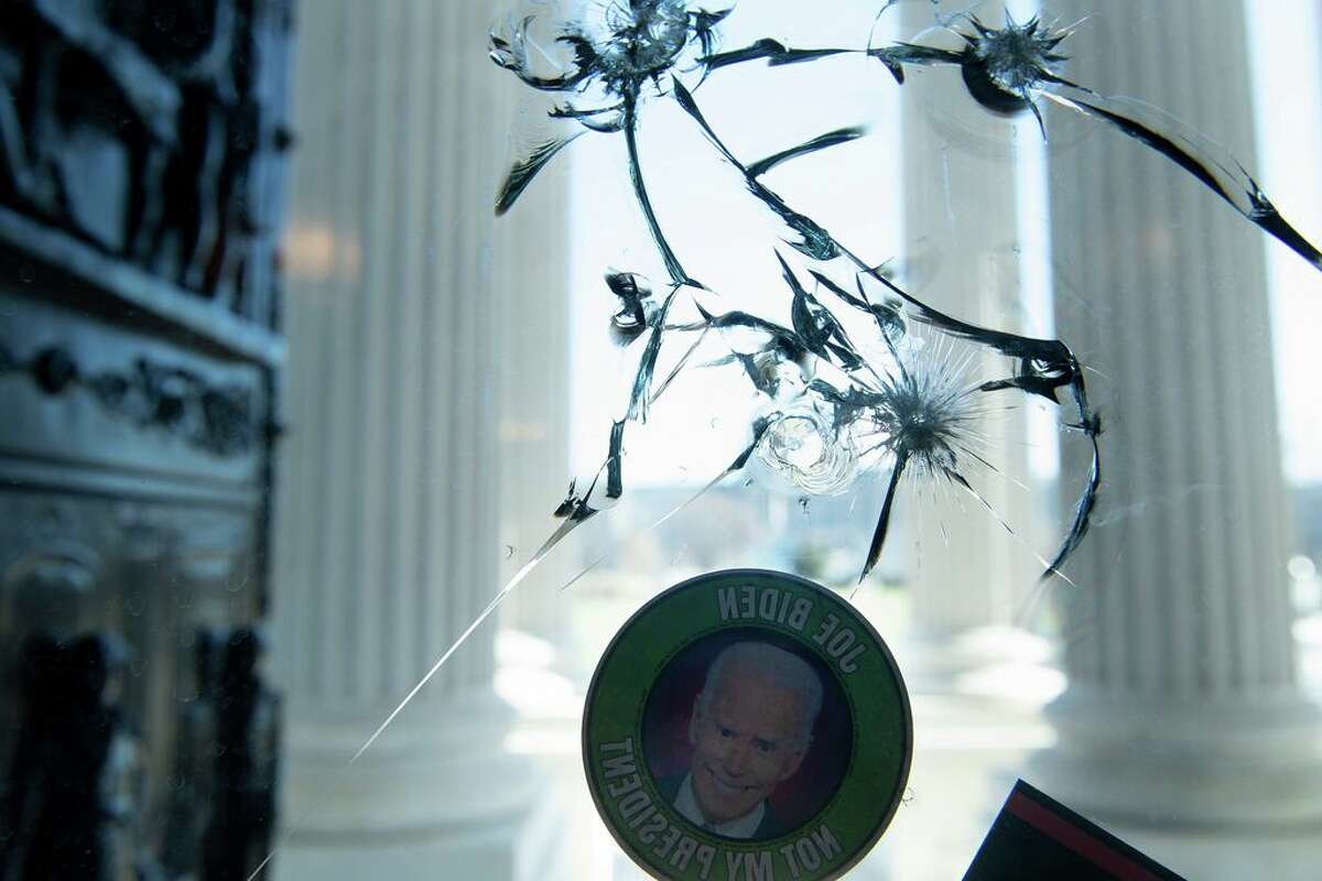 An anti-Biden sticker is seen on a cracked window a day after a pro-Trump mob broke into the US Capitol, January 7, 2021, in Washington, DC. (Photo by Brendan Smialowski / AFP)