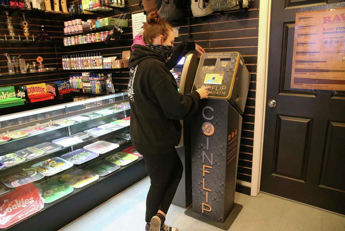 Bridgette McFarlin de Smokerz Paradise sur Pat Booker Road montre comment effectuer une transaction sur un guichet automatique Bitcoin.