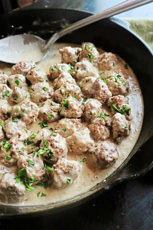 Roasted Swedish meatballs are served in a rich, roux-based gravy made with beef broth, heavy cream and sour cream. Cranberry sauce adds a bright and tangy garnish. (Gretchen McKay/TNS)