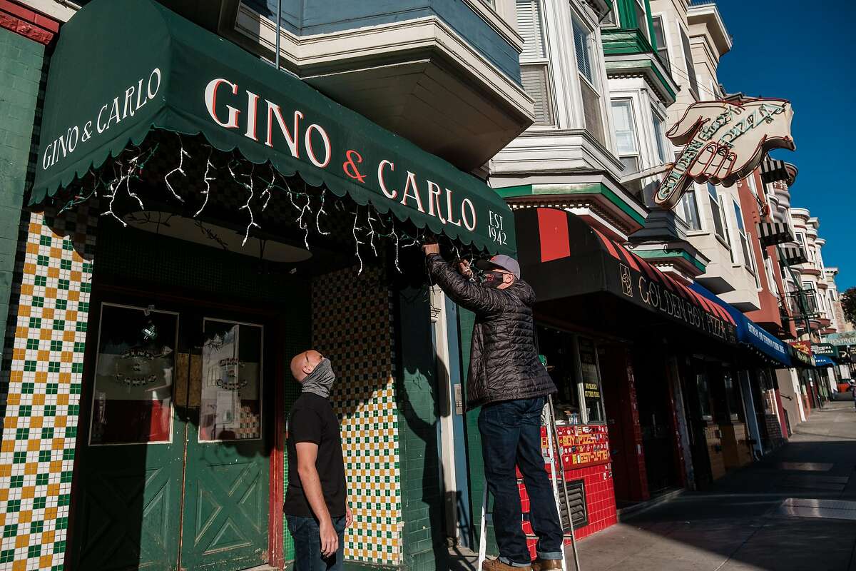 Gino & Carlo co-owners Frank Rossi Jr. (right) and Ronnie Minolli (left) do some work outside the famed watering hole in San Francisco on Thursday, December 31, 2020. San Francisco is extending its shelter-in-place order indefinitely, impacting business like Gino & Carlo bar in North Beach.