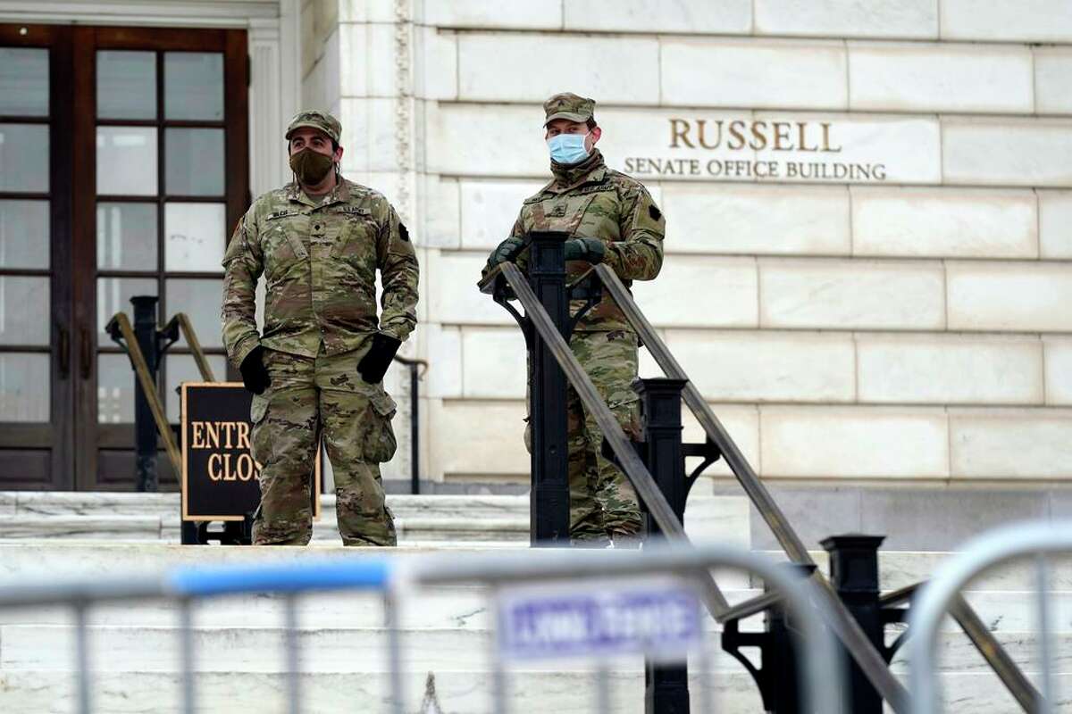 Members of the military stand guard outside Russell Senate Office Building on Capitol Hill in Washington, Friday, Jan. 8, 2021, in response to supporters of President Donald Trump who stormed the U.S. Capitol earlier in the week.
