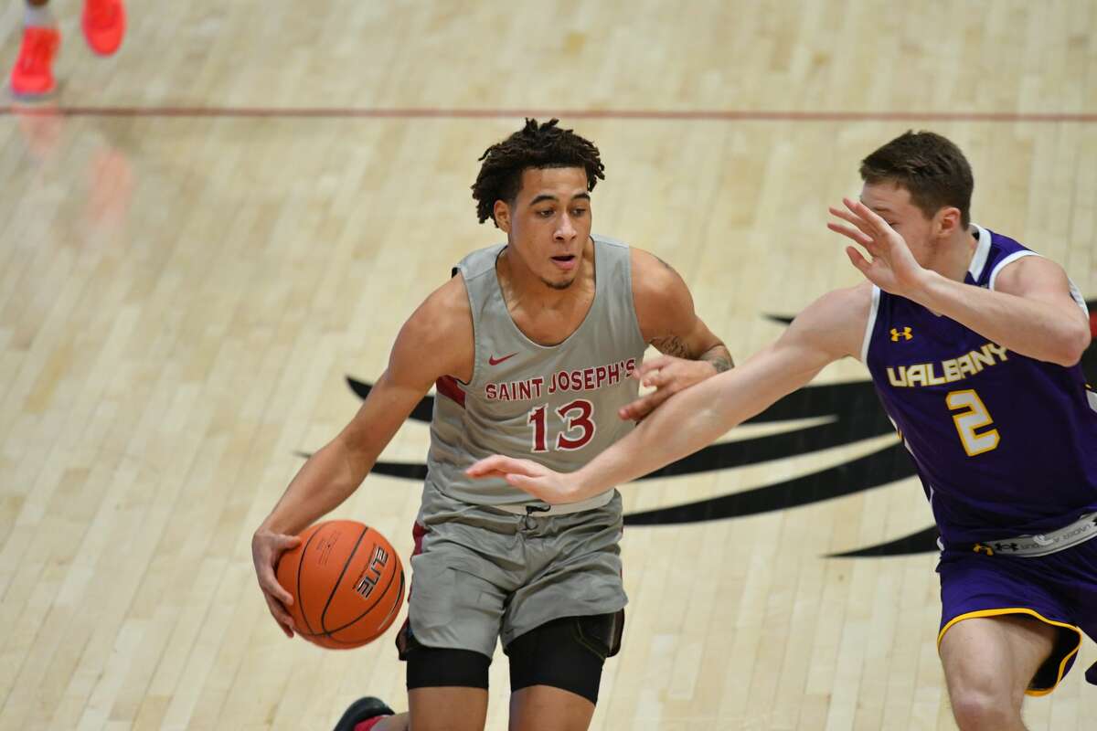 Jadrian Tracey of St. Joseph's tries to dribble past UAlbany's Trey Hutcheson on Saturday.