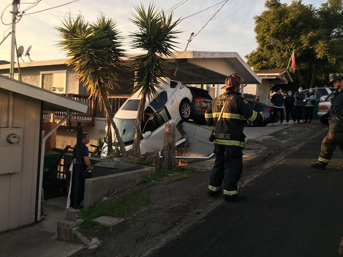 Video SUV crashes through San Leandro carport, dangles over embankment