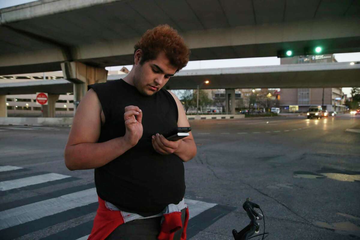 Isabella Cardenas, 22, texts with a friend after visiting her sister at a nearby motel near the corner of IH-35 and North Main Avenue, Wednesday, Jan. 6, 2021. Cardenas has been on the streets for a while and is now staying with friends in a tent under IH-37. San Antonio Regional Alliance for the Homeless, (SARAH), is partnering with five agencies to help area homeless youth through an almost $5 million grant to provide various programs, such as rapid rehousing, transitional housing and mobile outreach.