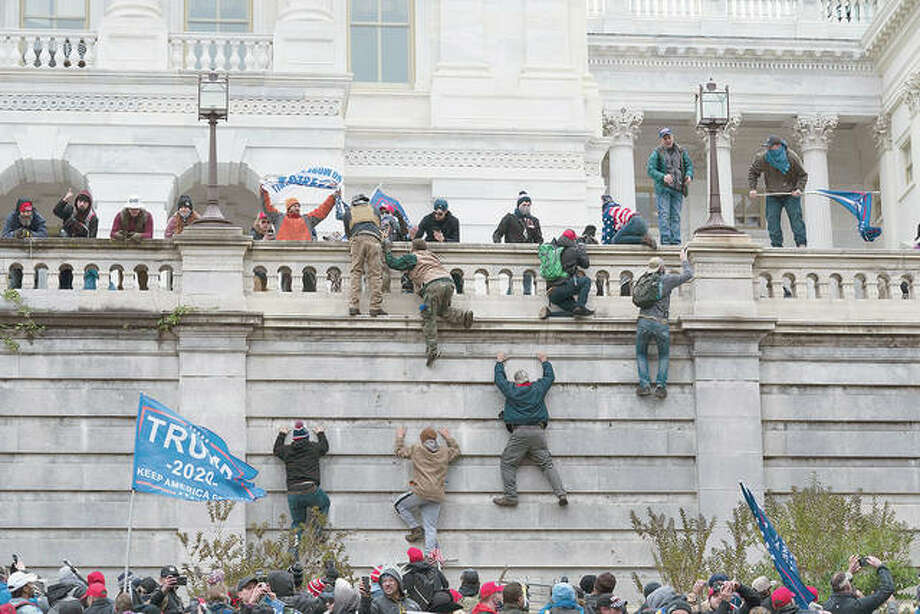 Randalierer erklimmen die Westwand des Washington Capitol Building.  Foto: Jose Luis Magana |  AP