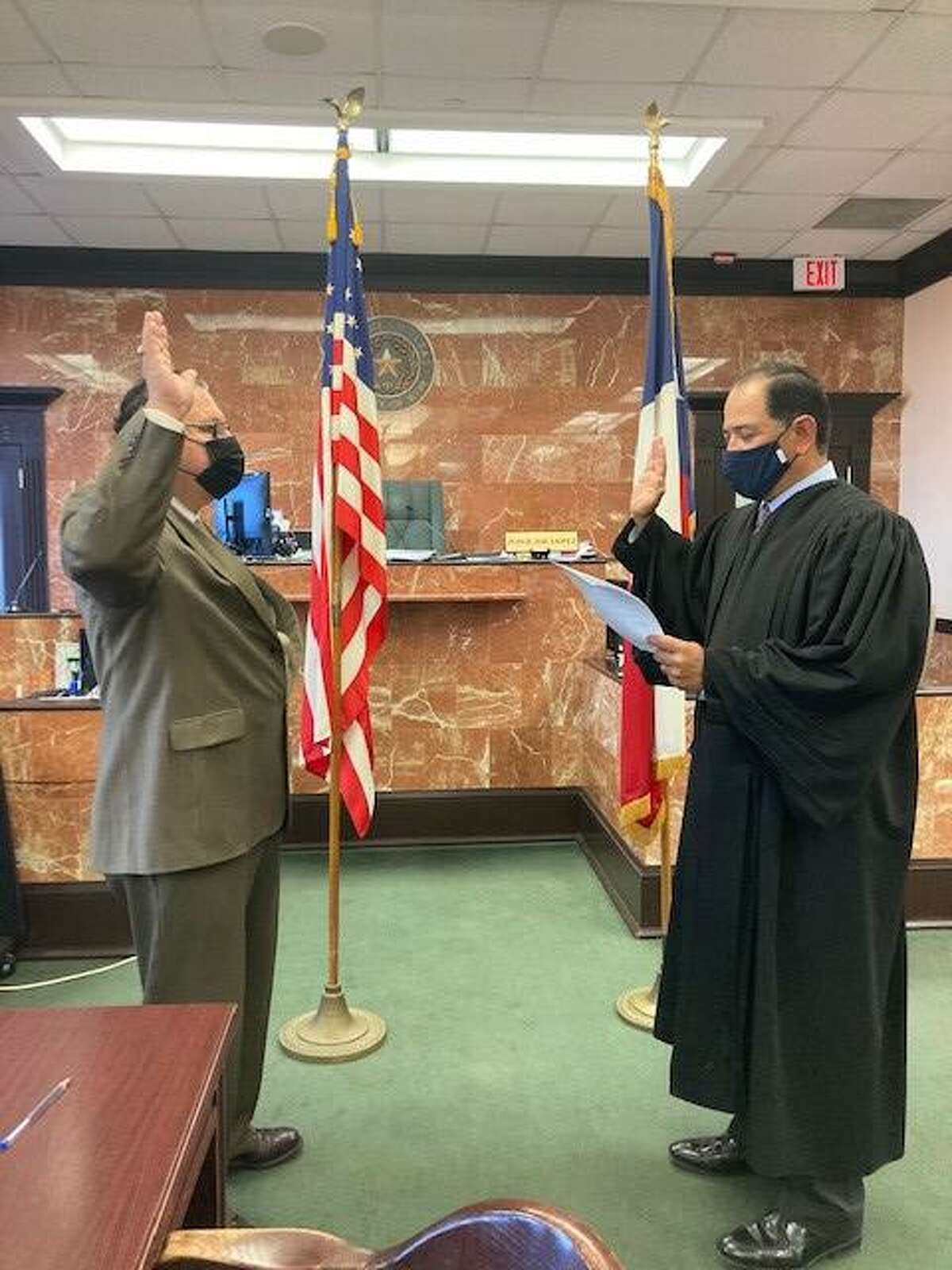 County Auditor Rafael Perez recites his oath of office with 49th District Court Judge Joe Lopez.
